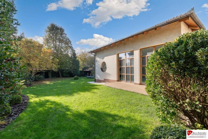 Predaj luxusná 5 izbová Vila,440 m2,pozemok 1061m2,garáž,bazén,BA II. - Rodinná vila s veľkým trávnikom na ulici Hrušovská obklopená zeleňou a stromami.