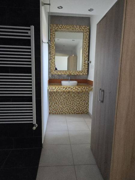 Prenájom ubytovacieho zariadenia – Šaľa Veča s kapacitou 50 osôb - Kúpeľňa s umývadlom, mozaikou a vešiakom na osušky, podlaha s dreveným dekorom.