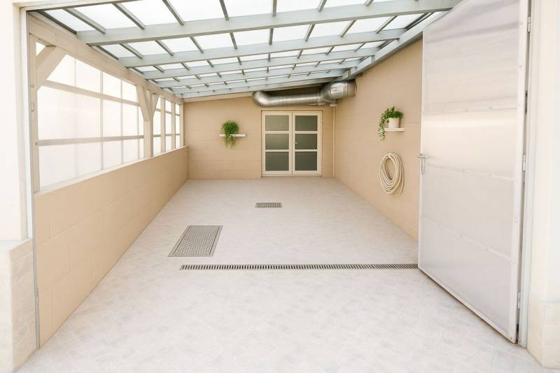 Na predaj ubytovňa / rodinný dom  v Šali  Veči s kapacitou 50 osôb - Krytá terasa s rastlinami, dverami a kanalizáciou v budove.