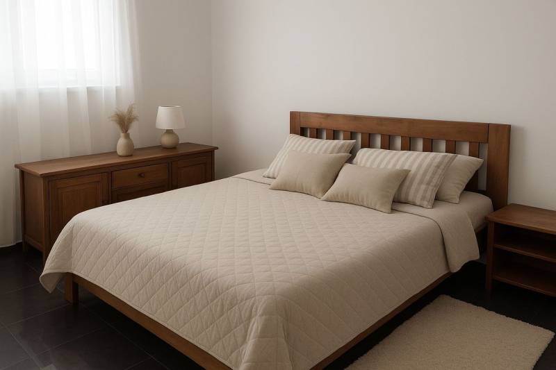 Na predaj ubytovňa / rodinný dom  v Šali  Veči s kapacitou 50 osôb - Spálňa s dreveným nábytkom, posteľou a dekoračnými vankúšmi, tlmené farby.