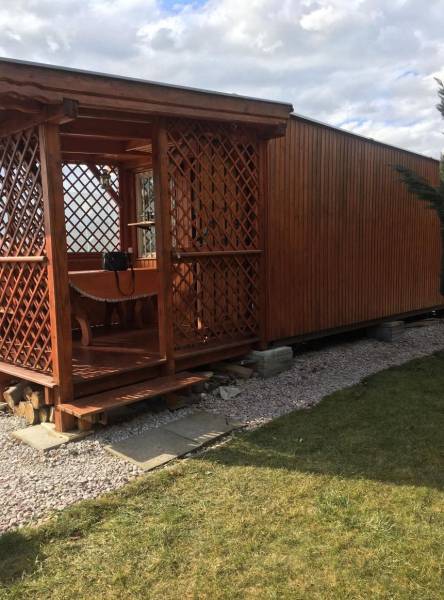 Záhrada na predaj – Kráľová nad Váhom 29 900 € - Dohoda Možná - Drevená chata v Kráľovej nad Váhom s malou vyvýšenou terasou a trávnikom.