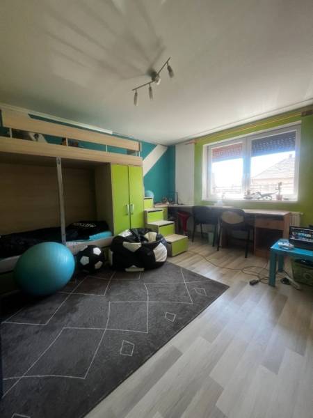 Rodinný dom s prístavbou na  podnikanie – Tešedíkovo - Detská izba v rodinnom dome s poschodovou posteľou, písacím stolom a podlahou s dreveným dekorom.