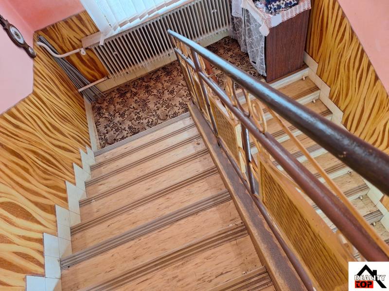 Výborný rodinný dom pre pohodlné bývanie - Schodisko s kobercom a podlahou s dreveným dekorom v rodinnom dome.