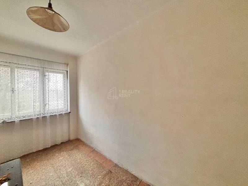 Predaj rodinného domu v Skalitom  - Izba v rodinnom dome s jedným oknom a závesom, s kobercovou podlahou.