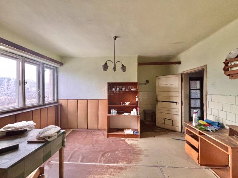 Predaj rodinného domu v Skalitom  - Izba v rodinnom dome s nábytkom, poličkami a veľkým oknom.