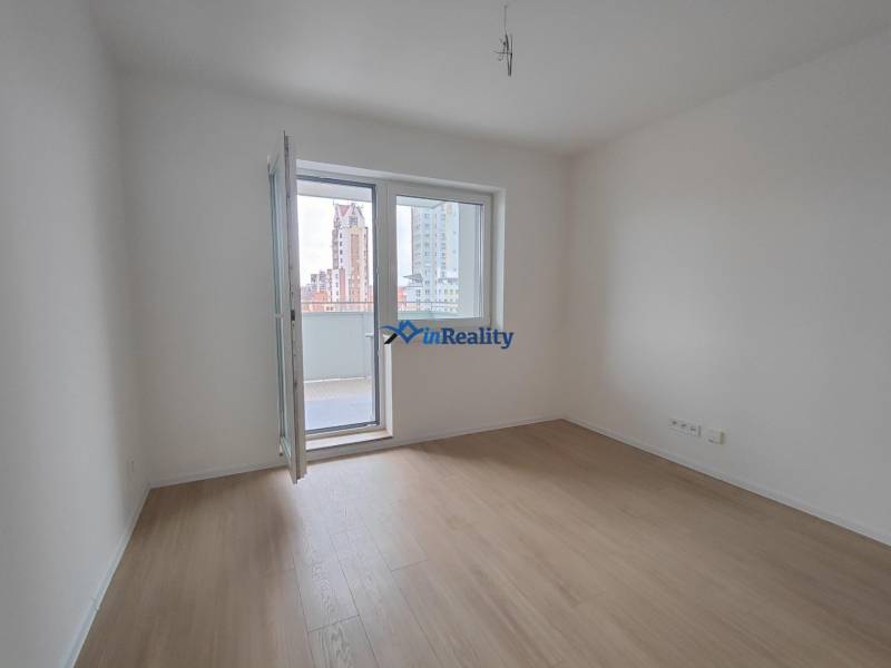  Na predaj moderný 2-izbový byt v Rezidencii Majakovského, Lučenec - Izba v 2-izbovom byte s podlahou s dreveným dekorom a balkónom.