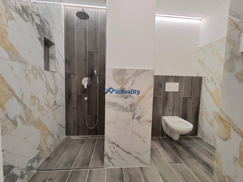  Na predaj moderný 2-izbový byt v Rezidencii Majakovského, Lučenec - Kúpeľňa v 2-izbovom byte s mramorovými obkladmi a podlahou s dreveným dekorom.