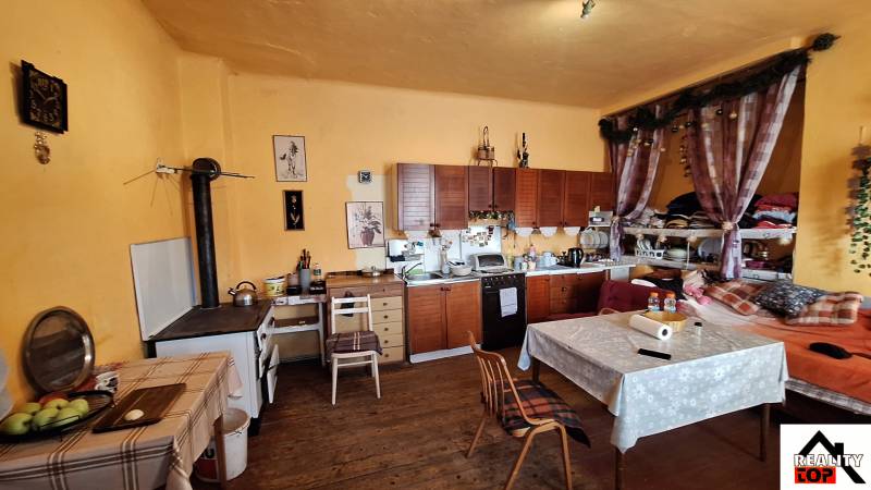 Hľadáte bývanie alebo investičnú príležitosť  - Kuchyňa s dreveným dekorom, rustikálnymi skrinkami a dekoráciami v rodinnom dome.