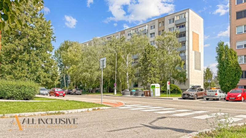PRÍJEMNÝ 3 IZBOVÝ BYT | P.O.HVIEZDOSLAVA | TOPOĽČANY - Ulica P.O. Hviezdoslava v Topoľčanoch so stromami a 3-izbovým bytom na pozadí.