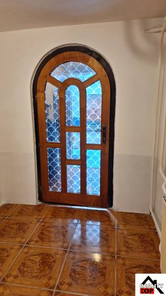 Investujte do budúcnosti - Klenuté drevené dvere so vzorovaným sklom v Rodinnom dome, podlaha s dreveným dekorom.