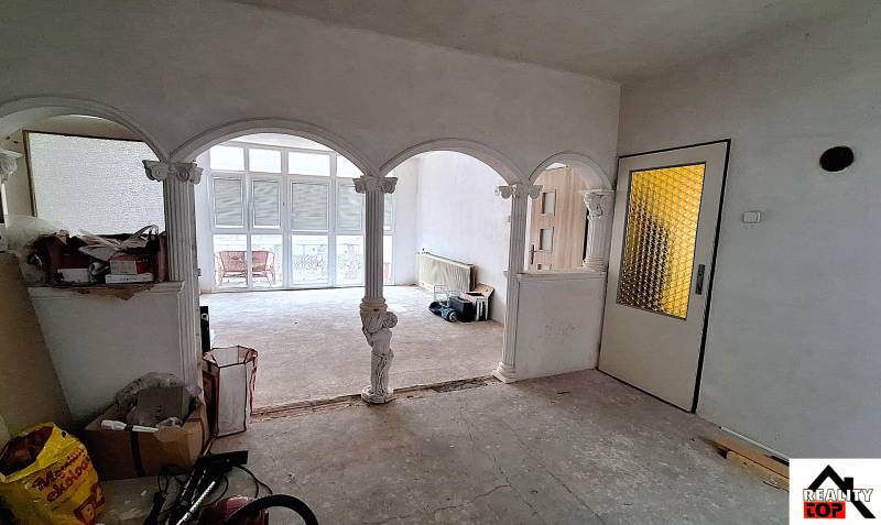 Investujte do budúcnosti - Interiér rodinného domu s klenutými oblúkmi a presklenými dverami. Opravy prebiehajú.