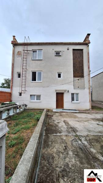 Investujte do budúcnosti - Rodinný dom v Zacharovciach s jednoduchou fasádou, oknami a vonkajším schodiskom.