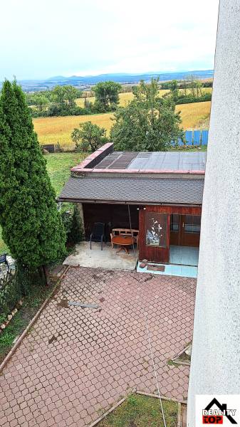 Investujte do budúcnosti - Záhrada Rodinného domu v Zacharovciach s altánkom, stromami a výhľadom na pole.