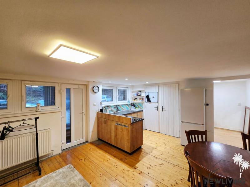 *PRENÁJOM* bezbariérový 1 izbový byt Lesná / Banka - Kuchyňa v 1-izbovom byte s podlahou s dreveným dekorom a stolom.