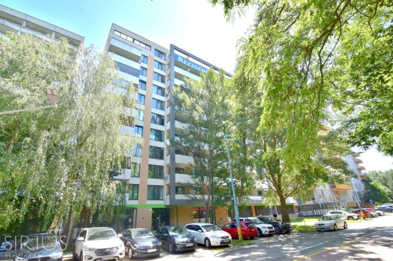 ANTOLSKÁ, 2-i byt, 54 m2 – novostavba REZIDENCIA DRAŽDIAK, zariadený - Bytový dom na Antolskej ulici v Bratislave - Petržalke, obklopený zeleňou a parkujúcimi autami.