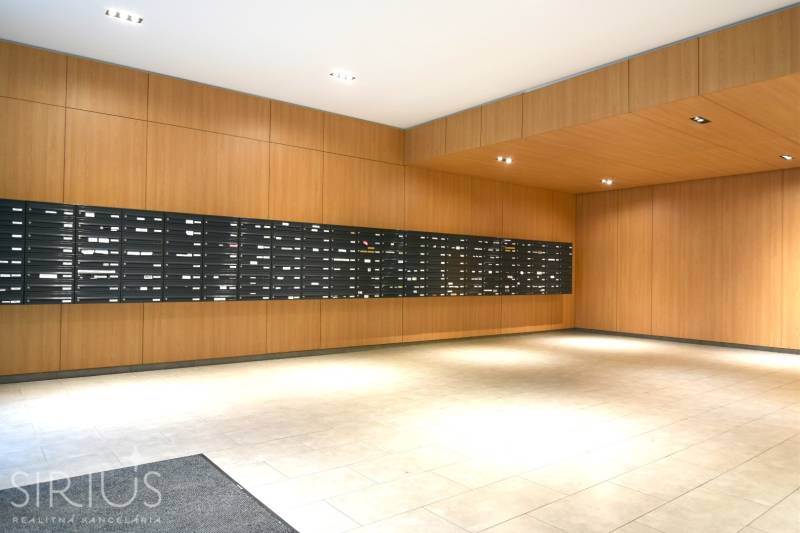 ANTOLSKÁ, 2-i byt, 54 m2 – novostavba REZIDENCIA DRAŽDIAK, zariadený - Obložené steny dreveným dekorom, poštové schránky, dlažba, interiér 2-izbového bytu.