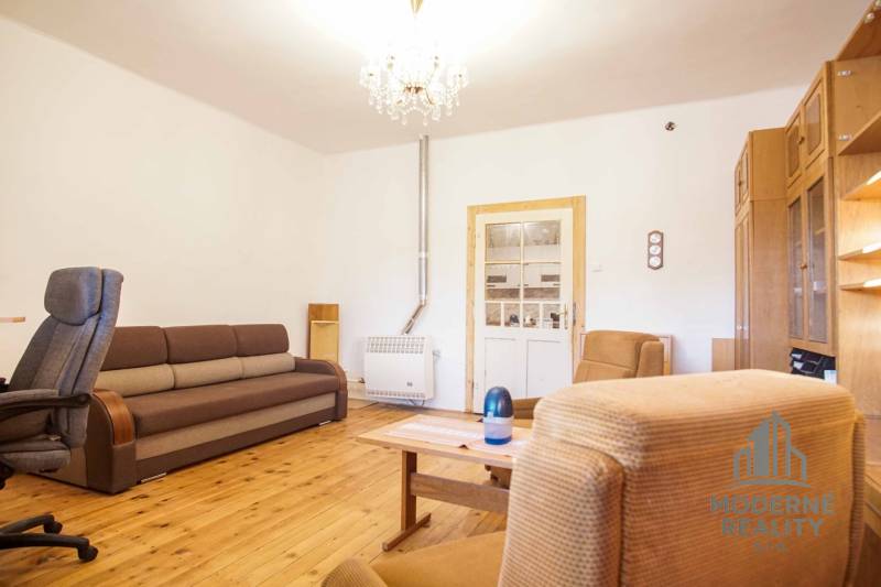 Rodinný dom s garážou na ul. Pod kopcom, Nové Zámky, 649m2 - Obývačka v rodinnom dome s podlahou s dreveným dekorom, sedačkou a kreslami.