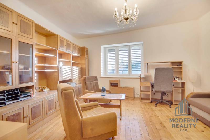 Rodinný dom s garážou na ul. Pod kopcom, Nové Zámky, 649m2 - Obývacia izba s nábytkom z dreva, podlaha s dreveným dekorom, luster.