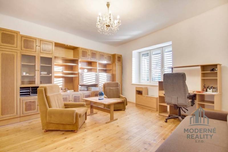 Rodinný dom s garážou na ul. Pod kopcom, Nové Zámky, 649m2 - Interiér rodinného domu s nábytkom, podlahou s dreveným dekorom a lustrom.