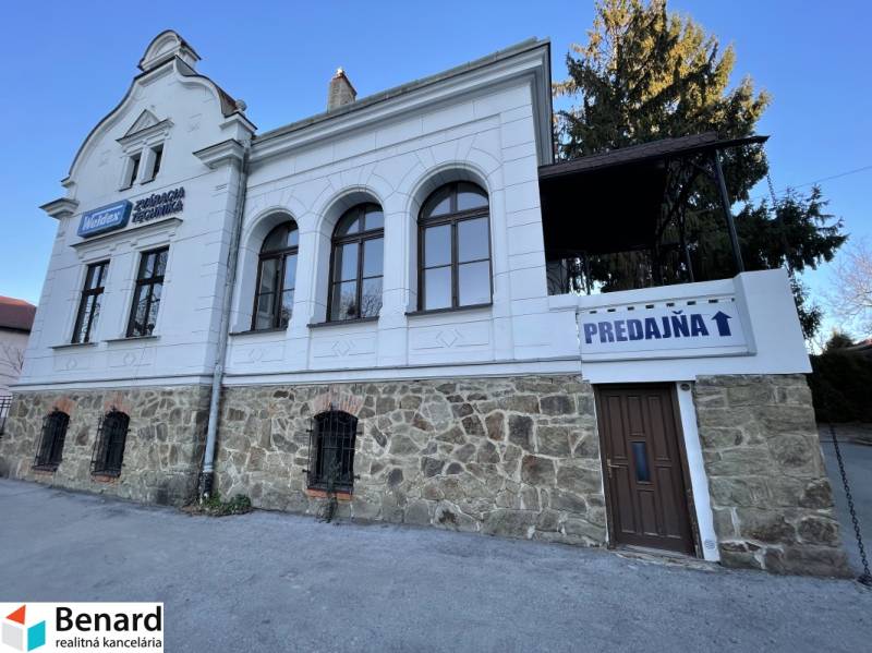 PREŠOV-ŠIRŠIE CENTRUM,POLYFUNKČNÁ BUDOVA,VL.PARKOVISKO,UL.VAJANSKÉHO - Budova na Vajanského ulici v Prešove s kamenným prízemím a nápisom 