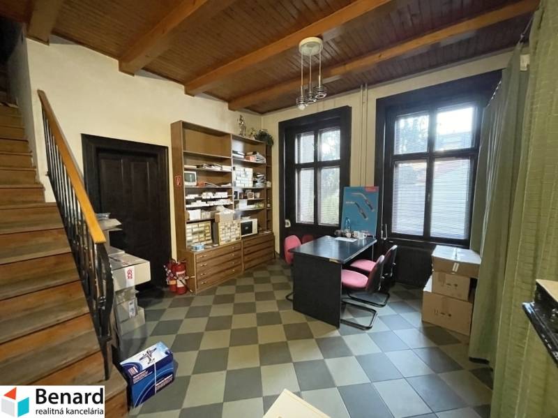 PREŠOV-ŠIRŠIE CENTRUM,POLYFUNKČNÁ BUDOVA,VL.PARKOVISKO,UL.VAJANSKÉHO - Interiér s dreveným stropom a podlahou s dekórom, obsahuje stôl so stoličkami a regály.