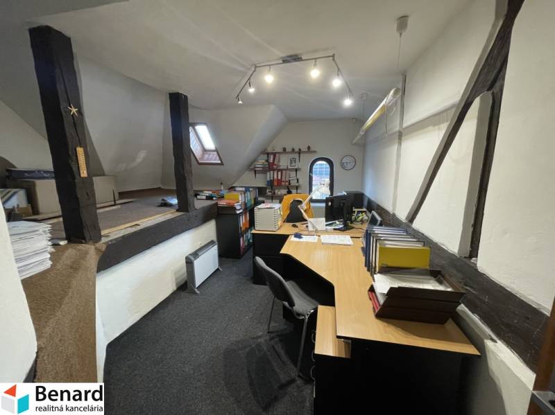 PREŠOV-ŠIRŠIE CENTRUM,POLYFUNKČNÁ BUDOVA,VL.PARKOVISKO,UL.VAJANSKÉHO - Kancelária v budove s drevenými trámami, vybavená stolmi a kancelárskymi potrebami.