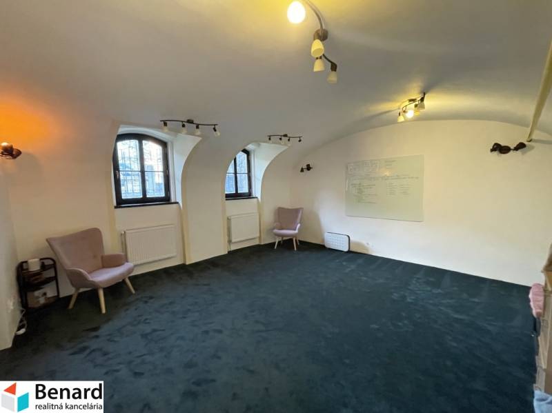 PREŠOV-ŠIRŠIE CENTRUM,POLYFUNKČNÁ BUDOVA,VL.PARKOVISKO,UL.VAJANSKÉHO - Interiér budovy s oblúkovými oknami, zeleným kobercom a nástennou tabuľou.