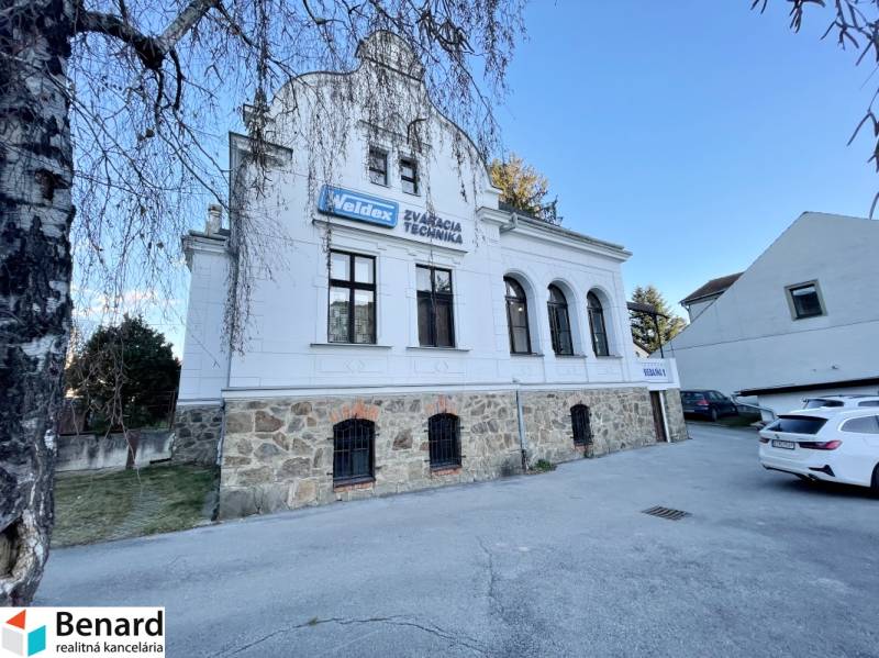 PREŠOV-ŠIRŠIE CENTRUM,POLYFUNKČNÁ BUDOVA,VL.PARKOVISKO,UL.VAJANSKÉHO - Budova na Vajanského ulici v Prešove s kamenným prízemím a bielou fasádou.