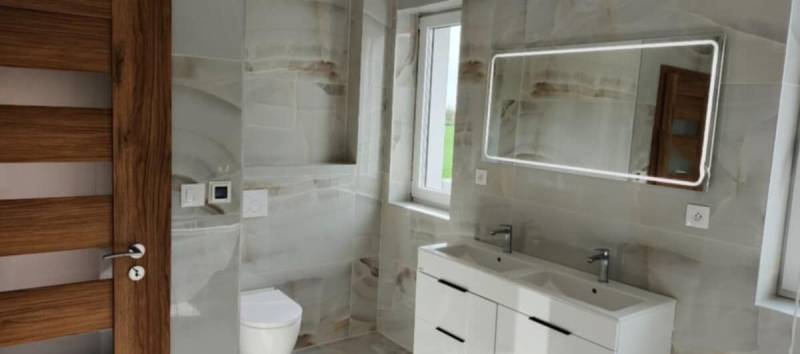 REZERVOVANÉ Na predaj 3-izbový byt v štandarde - Novostavba Diakovce - Kúpeľňa s moderným umývadlom, zrkadlom s osvetlením a obkladmi v 3-izbovom byte.