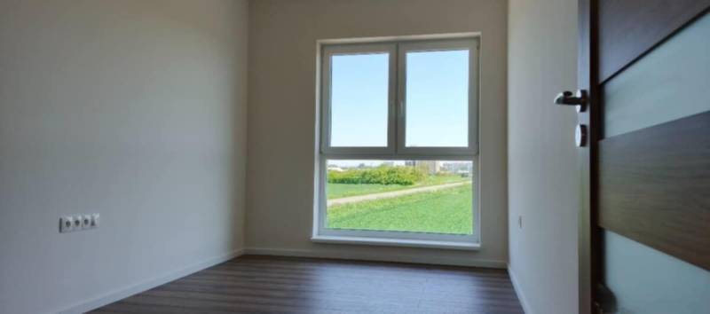 REZERVOVANÉ Na predaj 3-izbový byt v štandarde - Novostavba Diakovce - Svetlá miestnosť v 3-izbovom byte s podlahou s dreveným dekorom a veľkým oknom.