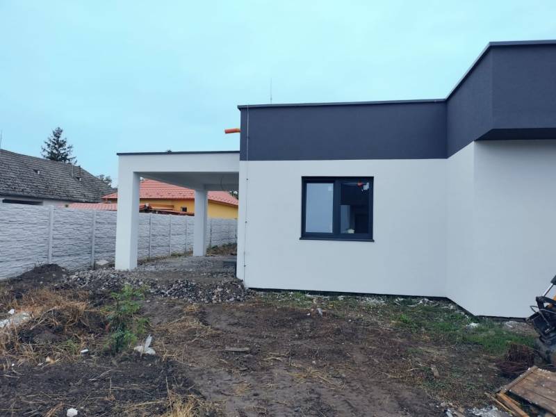 Novostavba 4-izbového rodinného dvojdomu v obci Žihárec - Rodinný dom v Žihárci s modernou fasádou a priľahlou pergolou na dvore.