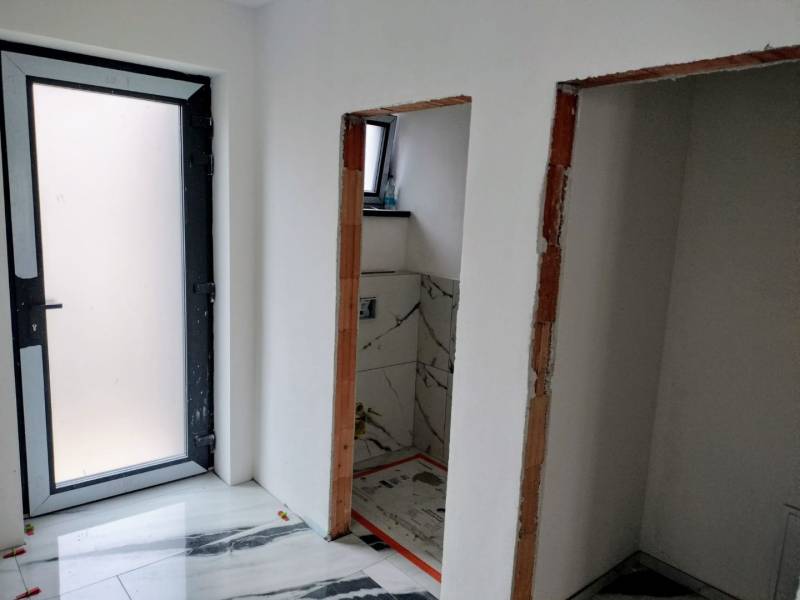 Novostavba 4-izbového rodinného dvojdomu v obci Žihárec - Interiér rodinného domu s bielymi stenami a podlahou s mramorovým vzorom.