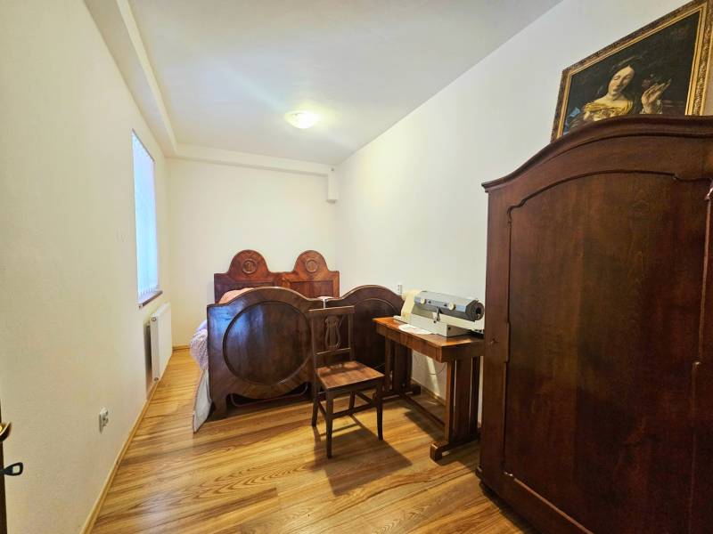  Veľkometrážny 3 izbový byt v kúpeľnom meste Trenčianske Teplice  - Spálňa s starožitným nábytkom, posteľou a skriňou s podlahou s dreveným dekorom.