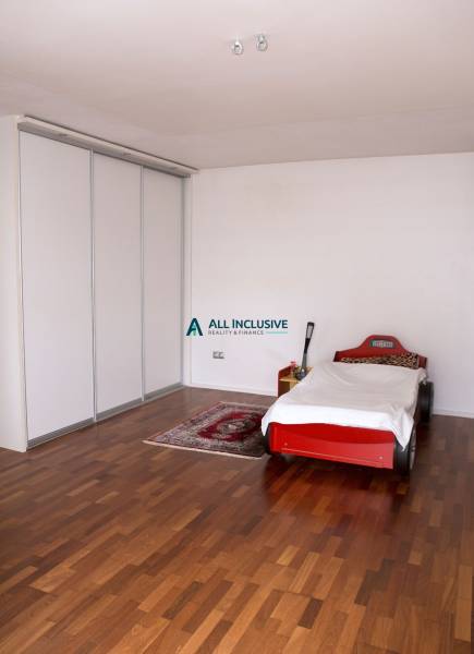 Na predaj rodinný dom na Súľovskej 56 v Bratislave - Detská izba v rodinnom dome s posteľou v tvare auta a podlahou s dreveným dekorom.