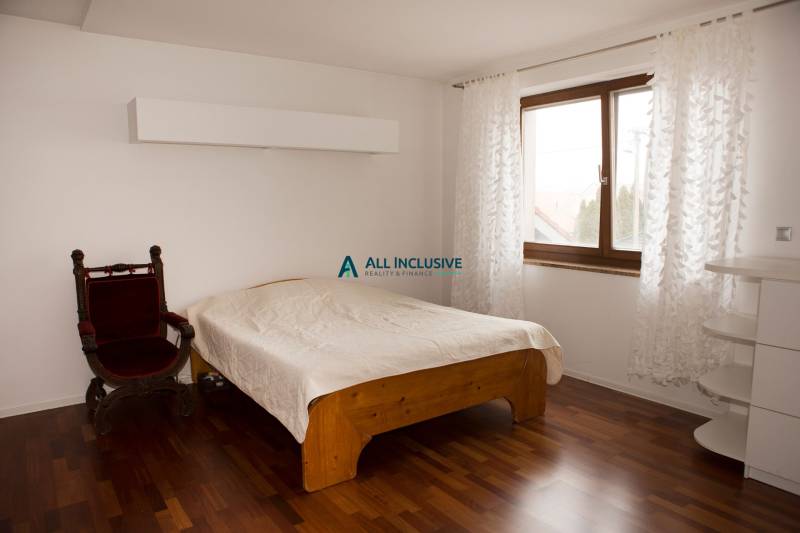 Na predaj rodinný dom na Súľovskej 56 v Bratislave - Spálňa v rodinnom dome s posteľou, kreslom a podlahou s dreveným dekorom.