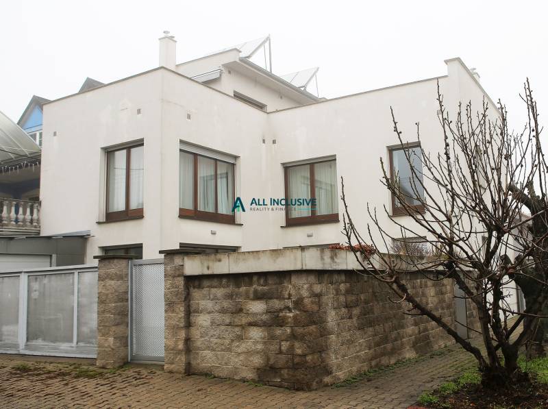 Na predaj rodinný dom na Súľovskej 56 v Bratislave - Rodinný dom na Súľovskej ulici, Bratislava - Ružinov s príjazdovou cestou a plotom z tehál.