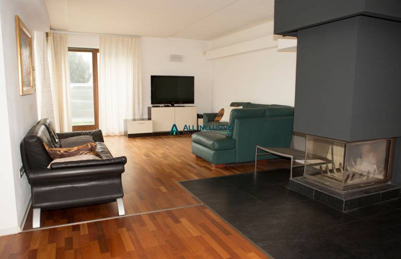 Na predaj rodinný dom na Súľovskej 56 v Bratislave - Obývacia izba s krbom, televízorom a podlahou s dreveným dekorom v rodinnom dome.