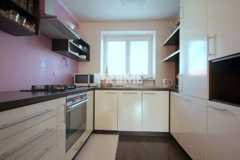 Moderný 2i byt, balkón, tehla, tichá lokalita, Kadnárova ul., Rača - Kuchyňa v 2-izbovom byte s plynovým sporákom a podlahou s dreveným dekorom.