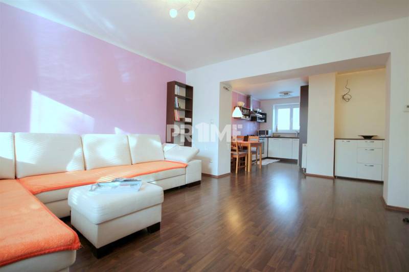 Moderný 2i byt, balkón, tehla, tichá lokalita, Kadnárova ul., Rača - Obývacia izba v 2-izbovom byte s rohovou sedačkou a podlahou s dreveným dekorom.