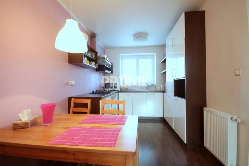 Moderný 2i byt, balkón, tehla, tichá lokalita, Kadnárova ul., Rača - Kuchyňa v 2-izbovom byte s podlahou s dreveným dekorom a ružovými doplnkami.