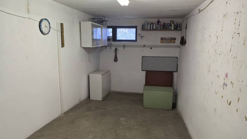 3-izbový byt so záhradou a garážou – Sadová ulica, Piešťany - Malá miestnosť so starým nábytkom, oknom, poličkou a hodinami na stene.