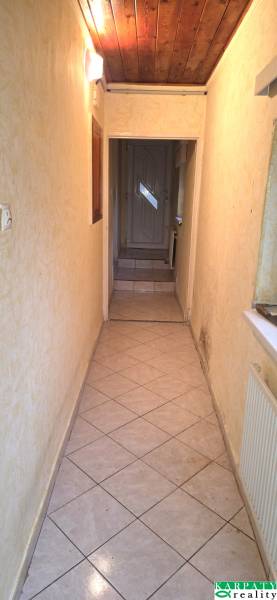 Na predaj rodinný dom Levice!. - Úzky interiérový chodník s dlažbou a dreveným stropom v rodinnom dome.