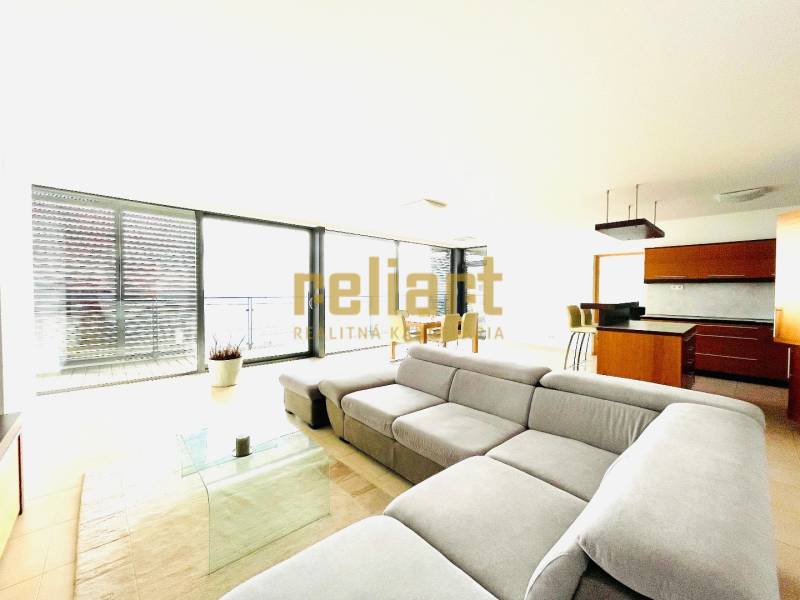 Koliba:Na prenájom 4i, lux. byt,terasa, bazén/eng.text inside - Obývacia izba v 4-izbovom byte s pohodlnou sedačkou a kuchynským kútom.