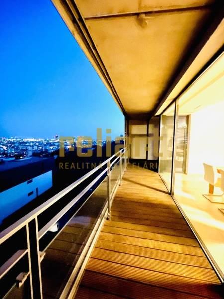 Koliba:Na prenájom 4i, lux. byt,terasa, bazén/eng.text inside - Nočný výhľad z balkóna 4-izbového bytu s podlahou s dreveným dekorom.