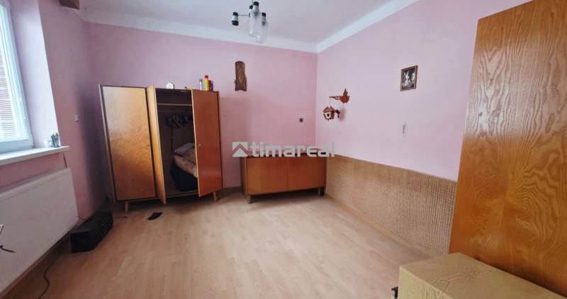 4i rodinný dom s garážou, 8á pozemok s vlastnou studňou, Križovany - Izba v rodinnom dome s ružovými stenami, šatníkom a podlahou s dreveným dekorom.