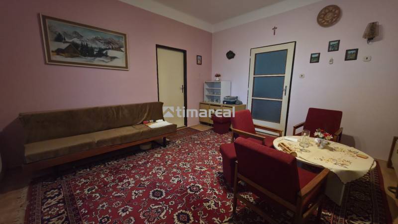 4i rodinný dom s garážou, 8á pozemok s vlastnou studňou, Križovany - Obývacia izba v rodinnom dome s červeným kobercom a dreveným nábytkom.