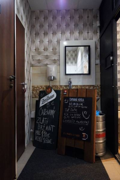 Kaviareň v Top lokalite mesta Šaľa na predaj - Interiérové obchodné priestory so zrkadlom, umývadlom a tabuľami s ponukou nápojov.