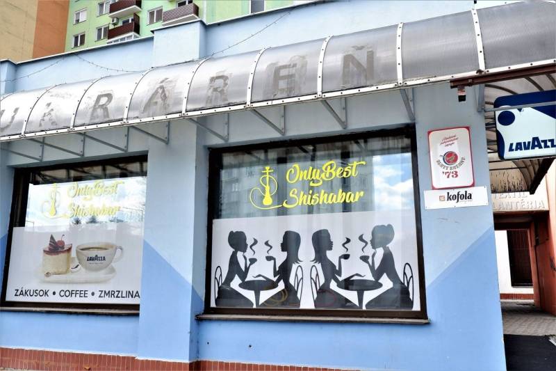 Kaviareň v Top lokalite mesta Šaľa na predaj - Exteriér obchodných priestorov v Šali s grafickými siluetami a reklamou na kávu Lavazza.