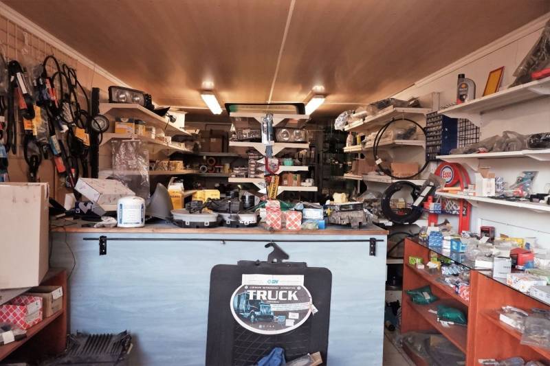 Prevádzková budova-AUTOSERVIS na predaj vo Veľkých Úľanoch - Predajňa autodielov s policami plnými súčiastok a príslušenstva vo výrobných priestoroch.