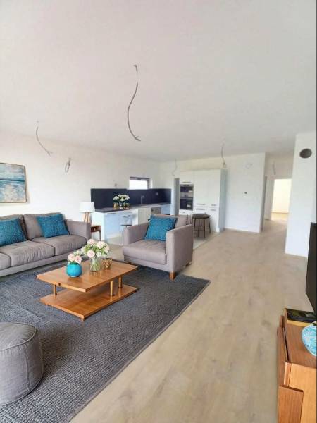 POSLEDNÁ Novostavba 4-izb rodinného domu v lukratívnej časti mesta - Obývacia izba v Rodinnom dome s podlahou s dreveným dekorom, sedačkou a dekoráciami.